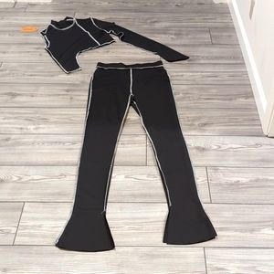 Black pants and top with white stitching. New, never worn.